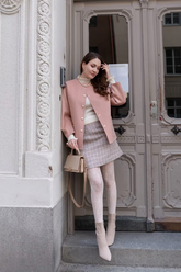 a lady in a pink jacket and a skirt
